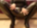 Squatting. Leather leggings and overknee boots