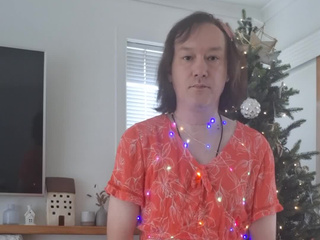 In a red dress with lights by the Christmas tree