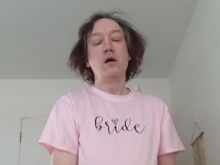 I'm sitting on the bed with my legs spread in a pink T shirt