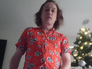 In a red shirt, naked near a small New Year tree, view from below