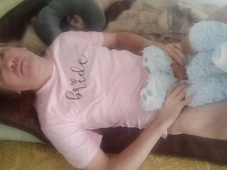 Lying with a teddy bear in a pink T shirt